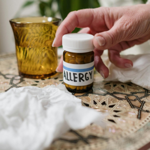 A close-up of allergy medication bottle on table with tissues, ideal for health themes.
